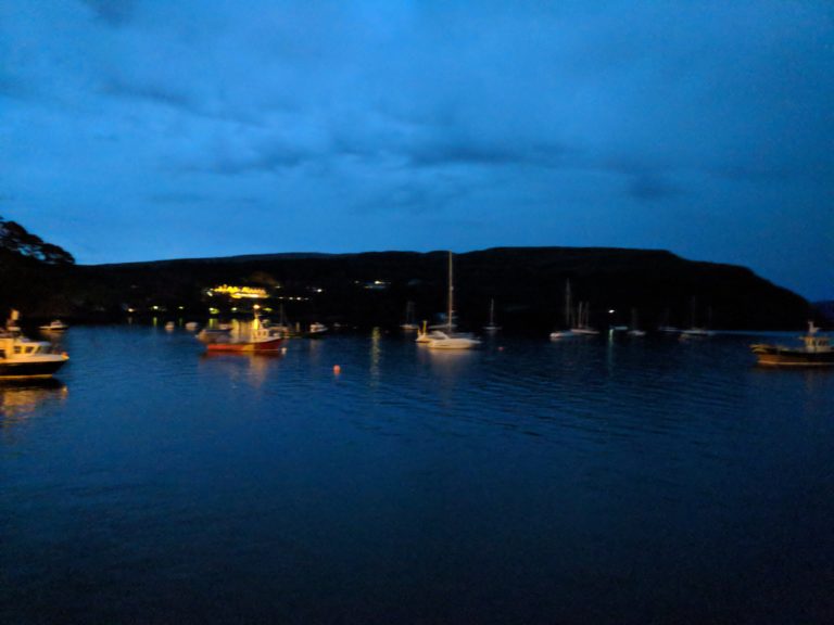 View of the mystique blue water by the Portree Harbor at midnight