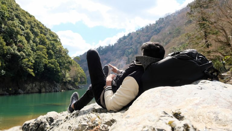 Laying with one foot up by the river