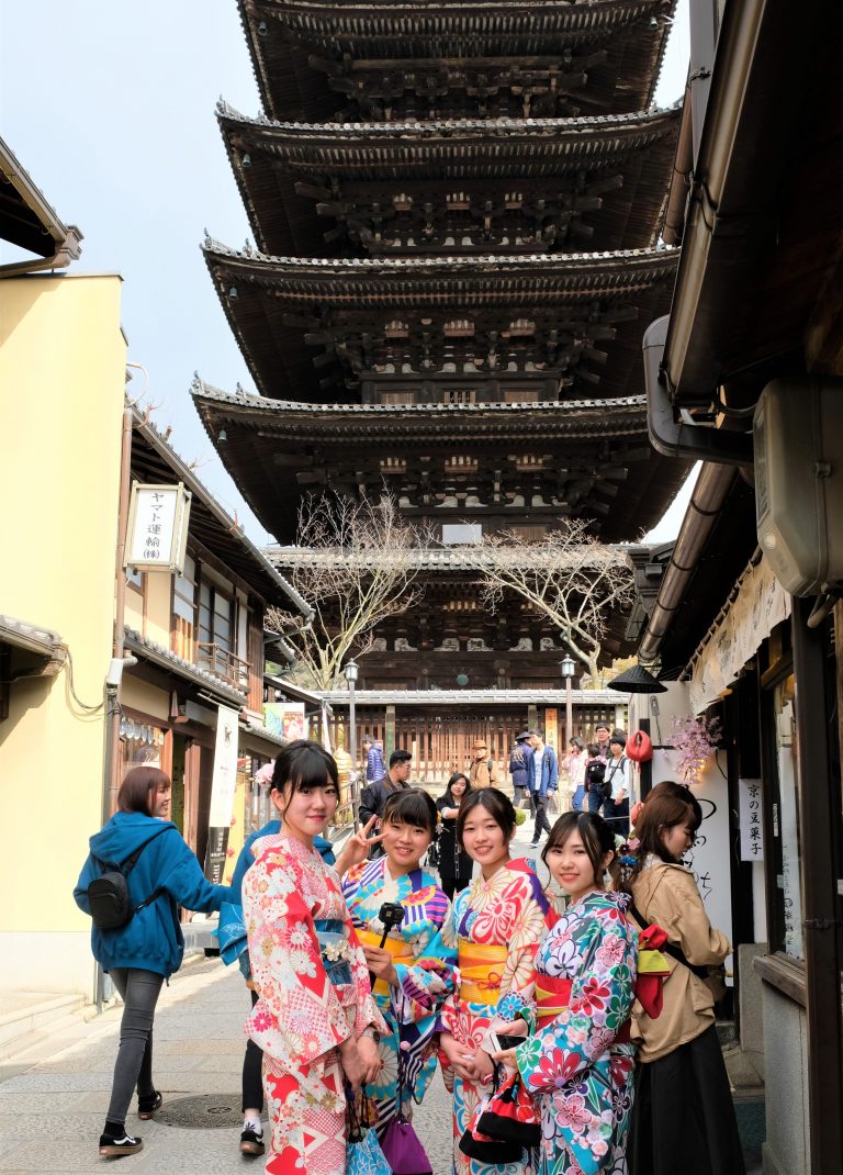 Japanese tourist dressed in Kimonos pose in front of the Yasaka Pagoda