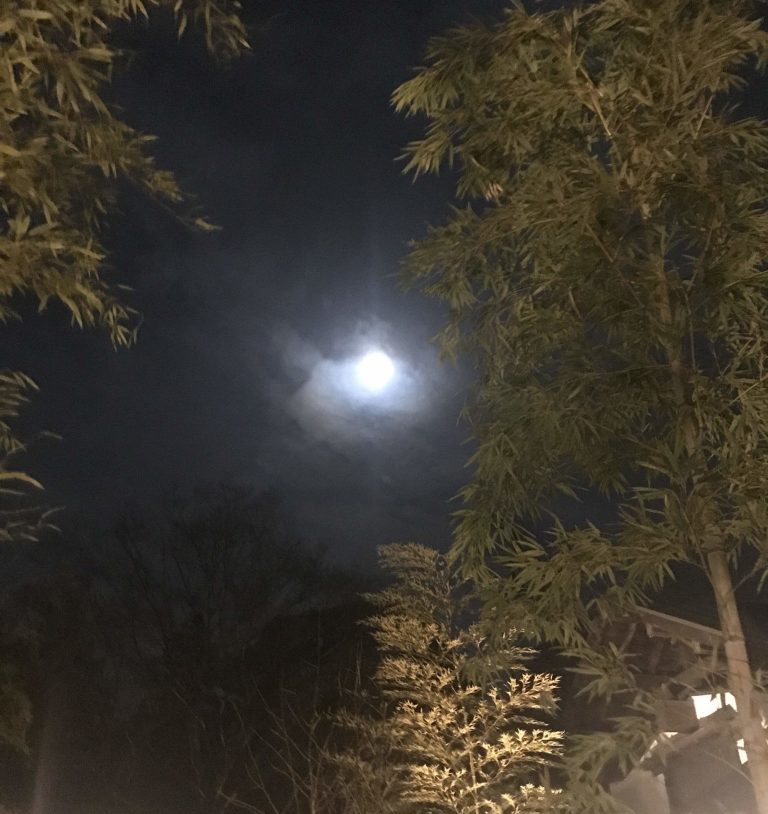 A full moon illuminates the night sky above Yuryo Onsen in Japan