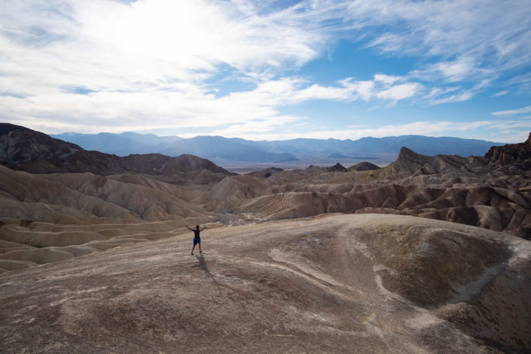 A wide angle shot of Nishil with his hands out at Zabriskie Point