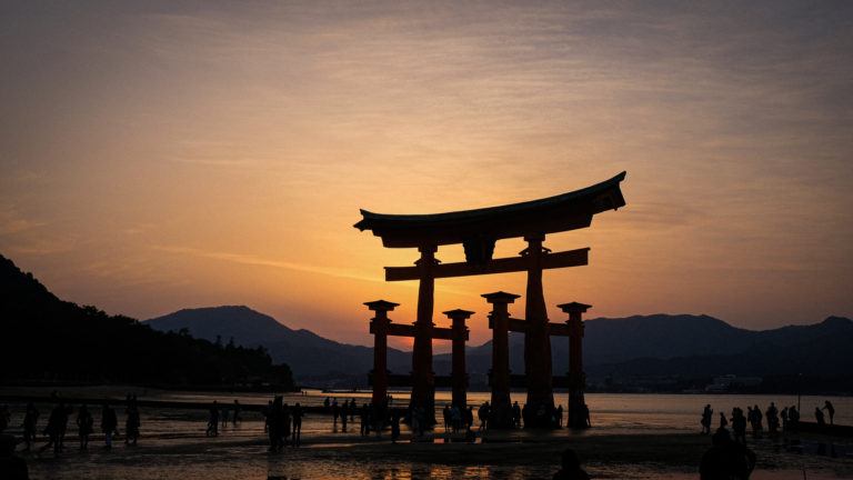 The sun sets behind a floating shrine in Miyajima Isaland