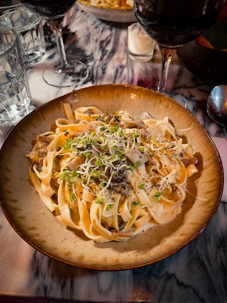 Pasta in a wooden bowl with garnish on top
