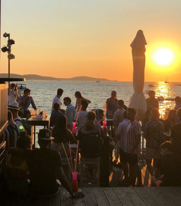 Sitting on the steps pf the bar as sun sets by the sea in Hvar